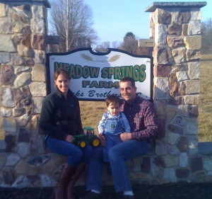 Jamie Hicks (from left) sits with his son, Graham, and wife Kate at the entrance to Meadow Springs Farm.