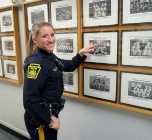 Kennett Square Police Officer Sarah London, the new school resource officer at Kennett High, points to a 2001 photo of her on the school's cheerleading squad.  