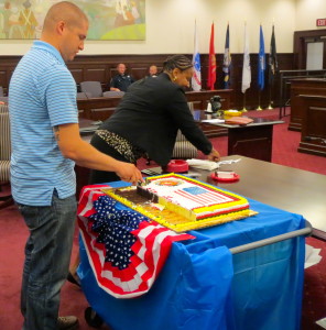 Louis A. Freda II gets assistance from Probation Officer Donna Brown during his cake-cutting duties at his Veterans Court graduation ceremony.