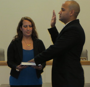 Tairy Melendez (left) holds the Bible for her husband, as he is sworn is as a part-time police officer in New Garden Township.