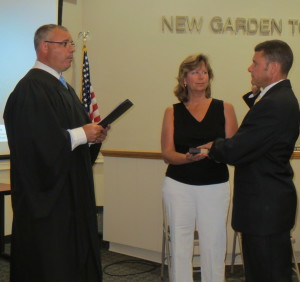 Magisterial District Judge Matthew Seavey (left) swears in former state police corporal Michael King as his wife, Cathy King, holds the Bible.