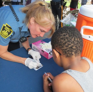 Officer Jennifer Albertson, a West Chester native whose favorite food is watermelon, signs one of her cards.