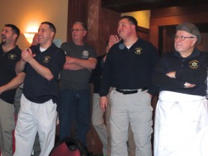 Kenneth Rongaus (right) and a crew of deputy sheriffs react to accolades from the audience after the meal.