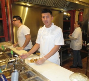 Armando Bernal (from left) takes an order as Daniel Castaneda puts toppings on a fish taco that Martha has just prepared. 