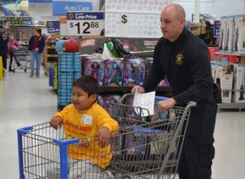 A cart chauffeured by Deputy Sheriff Mike Sarro delights a young shopper. 